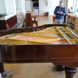 Il pianoforte riverniciato e lucidato durante la fase conclusiva del restauro 